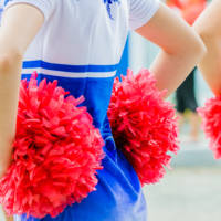 young female cheerleaders holding pom-poms young female cheerleaders holding pom-poms during competitions